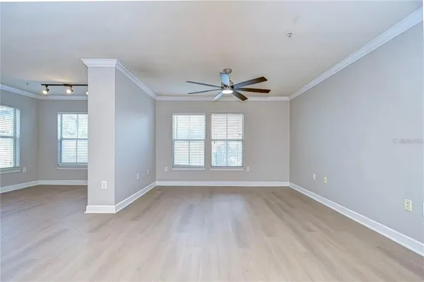 a view of an empty room with a window and wooden floor