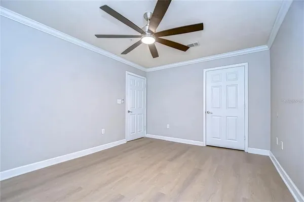 an empty room with ceiling fan and window