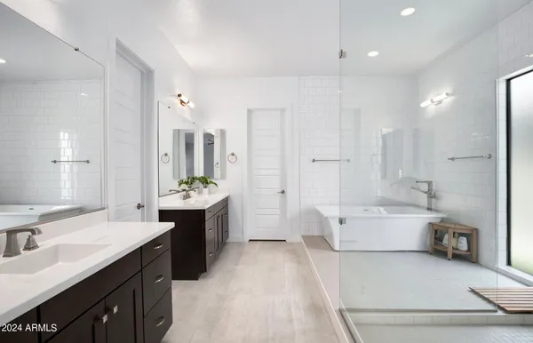a bathroom with a tub shower and view of a bathroom
