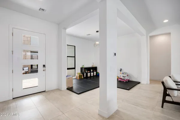 a living room with furniture kitchen view and a chandelier