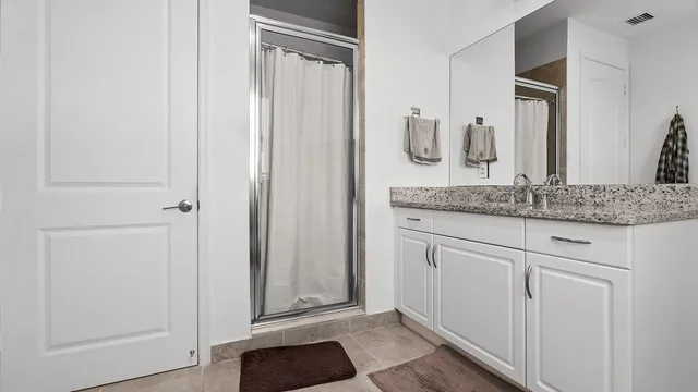 a bathroom with a granite countertop sink and mirror