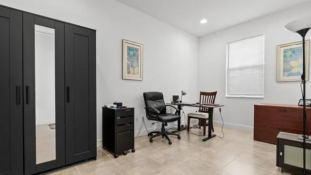 a view of a workspace with furniture and a window