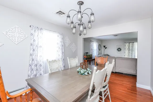 a dining room with furniture a chandelier and wooden floor