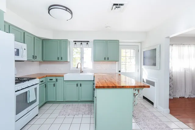 a large kitchen with kitchen island a sink stainless steel appliances and cabinets
