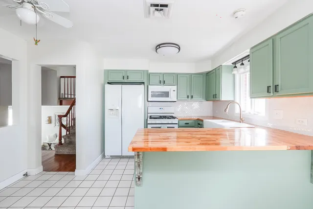 a kitchen with kitchen island a table and chairs in it