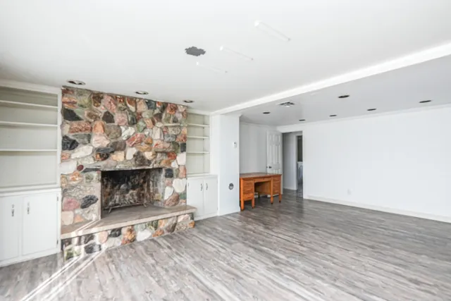 an empty room with fireplace and fan