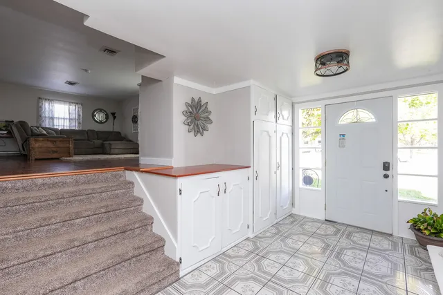 a view of a hallway to a bedroom with wooden floor and windows