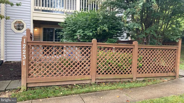 a side view of a white building with wooden fence