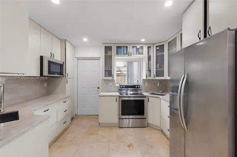 a kitchen with stainless steel appliances granite countertop a refrigerator and a stove top oven