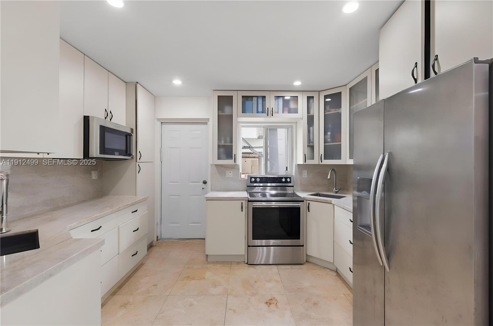 1601 Bay Road, Unit 4 Miami Beach, FL 33139 - Photo 4 of 17 a kitchen with stainless steel appliances granite countertop a refrigerator and a stove top oven