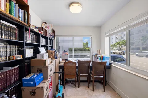 a view of a workspace with furniture and a book shelf