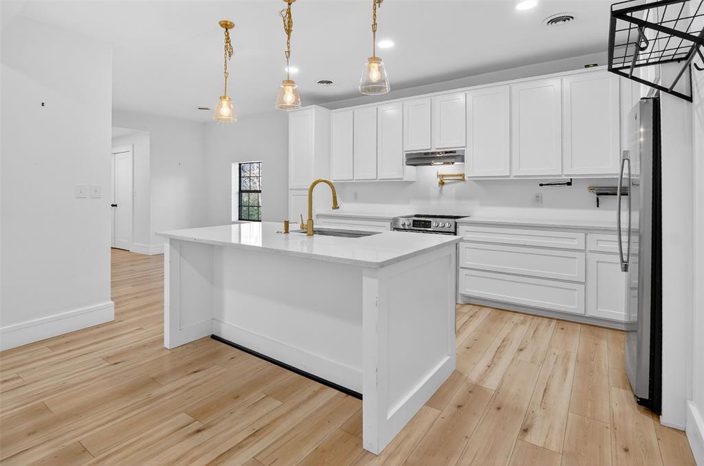 2218 Lynnhaven Road Fort Worth, TX 76103 - Photo 12 of 37 a kitchen with stainless steel appliances granite countertop a white cabinets and wooden floor