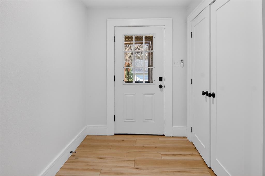 2218 Lynnhaven Road Fort Worth, TX 76103 - Photo 27 of 37 a view of a hallway with wooden floor and a bathroom