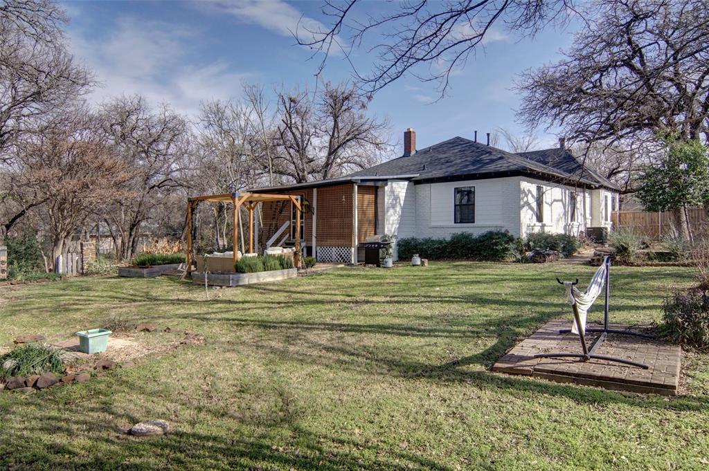 2218 Lynnhaven Road Fort Worth, TX 76103 - Photo 35 of 37 a front view of a house with a yard table and chairs