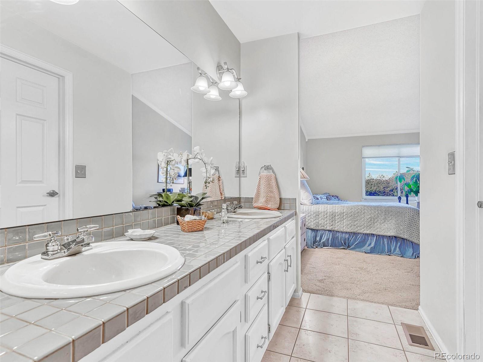 9 Stonehaven Court Highlands Ranch, CO 80130 - Photo 20 of 40 a bathroom with a double vanity sink a mirror and a shower