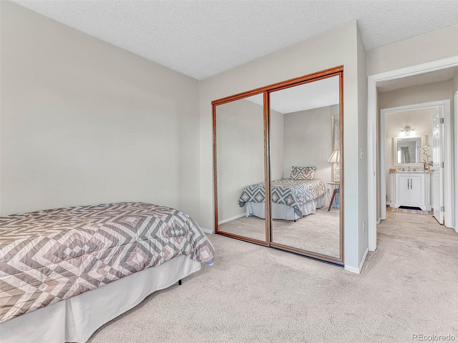 9 Stonehaven Court Highlands Ranch, CO 80130 - Photo 22 of 40 a bedroom with a bed and glass door