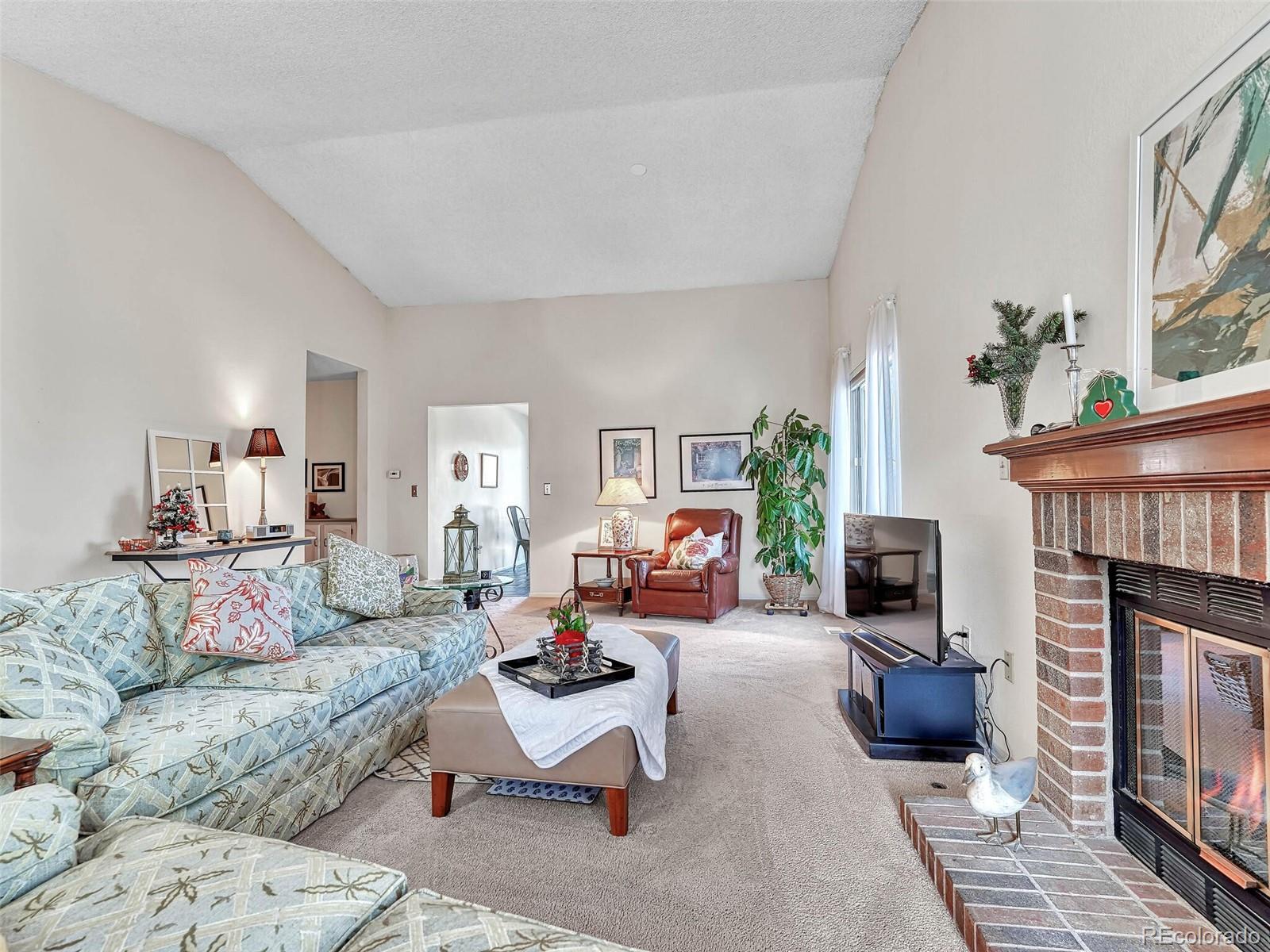 9 Stonehaven Court Highlands Ranch, CO 80130 - Photo 3 of 40 a living room with furniture a fireplace and a table
