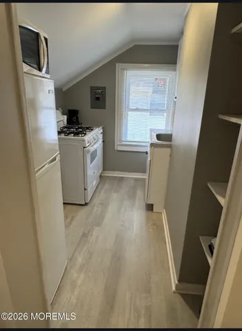 a view of a kitchen with a sink refrigerator and window
