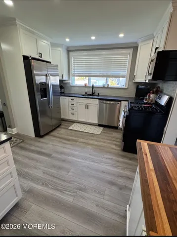 a kitchen with stainless steel appliances kitchen island granite countertop a refrigerator stove and oven