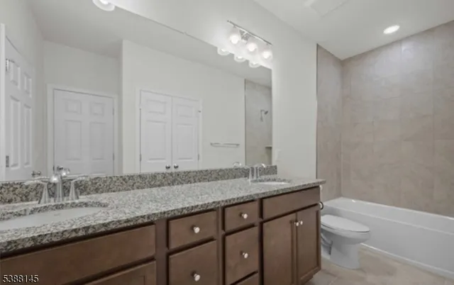 a bathroom with a granite countertop double vanity sink and a mirror