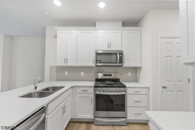 a kitchen with stainless steel appliances granite countertop a sink and a stove top oven