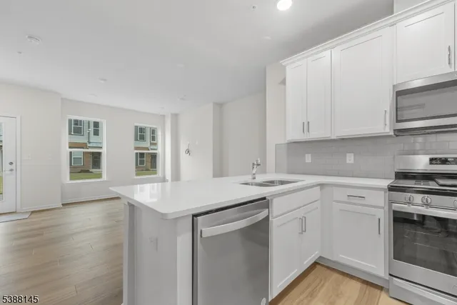 a kitchen with stainless steel appliances granite countertop a sink stove and cabinets