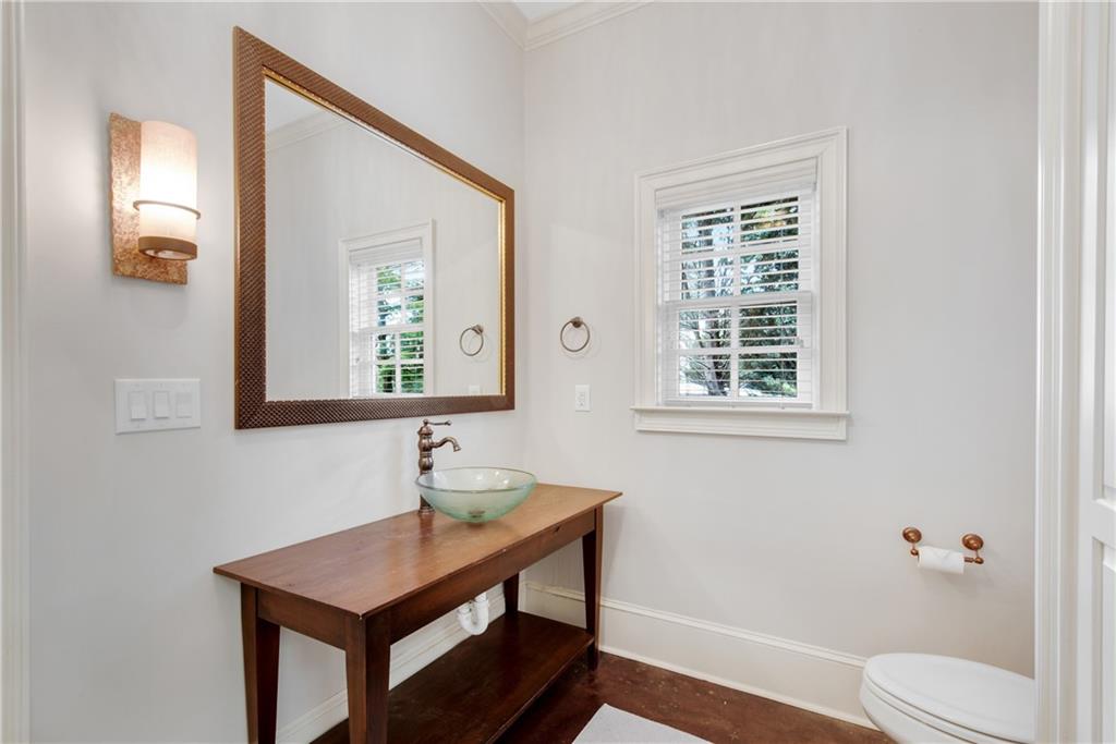 13942 Tree Loft Road Milton, GA 30004 - Photo 75 of 102 a bathroom with a toilet a sink a mirror and a window
