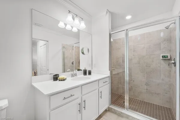 a bathroom with a double vanity sink mirror and shower