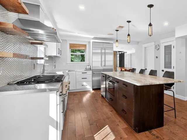 a kitchen with stainless steel appliances granite countertop a stove a sink dishwasher and a refrigerator