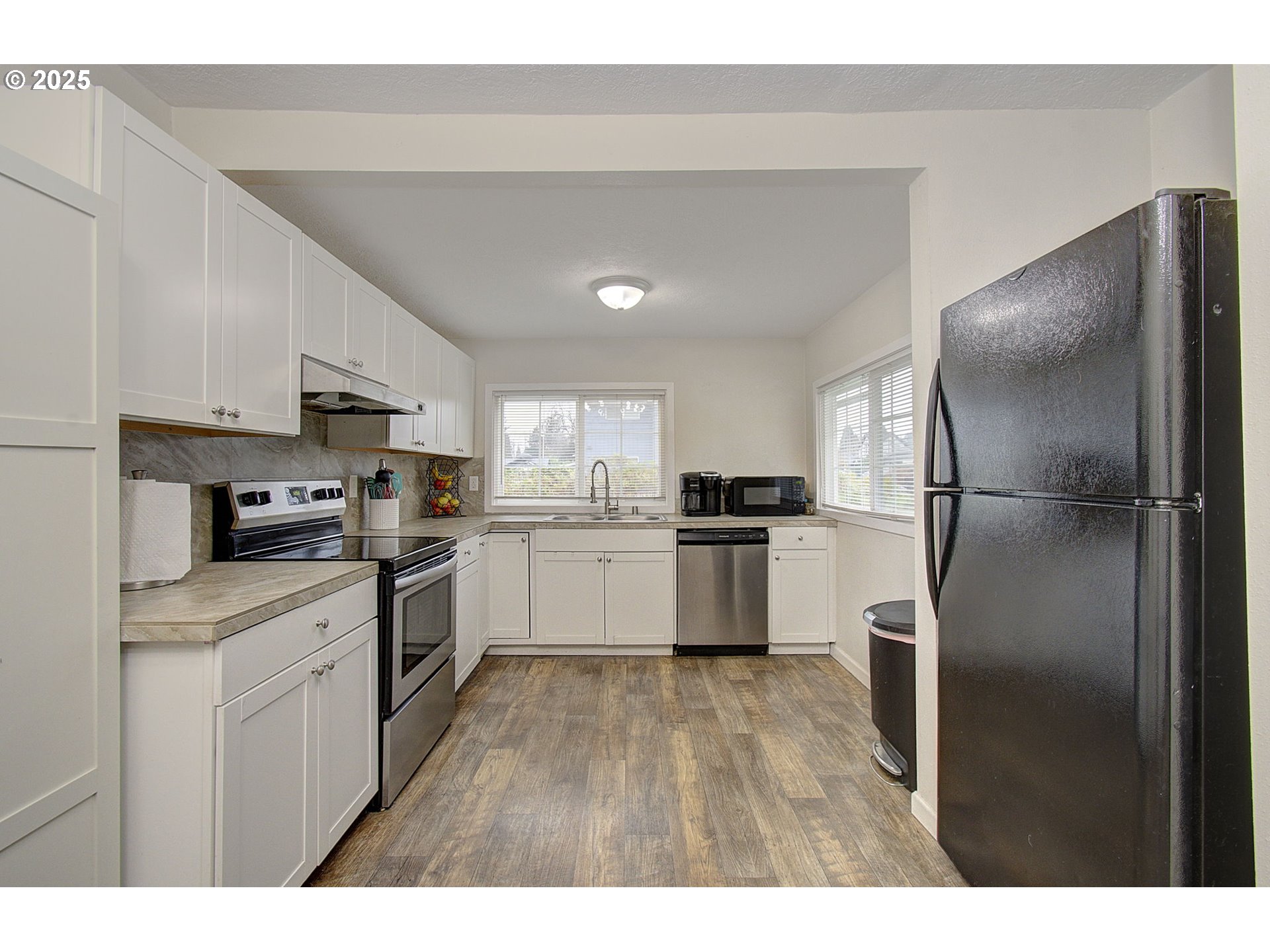 511 4th Avenue Southwest Castle Rock, WA 98611 - Photo 12 of 37 a kitchen with white cabinets and stainless steel appliances