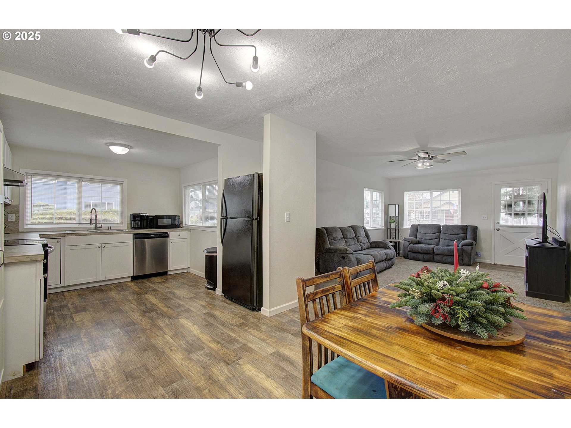 511 4th Avenue Southwest Castle Rock, WA 98611 - Photo 9 of 37 a kitchen with stainless steel appliances kitchen island granite countertop a refrigerator a stove a sink dishwasher and white cabinets with wooden floor