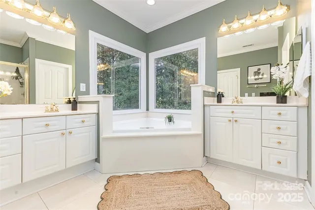 a spacious bathroom with a granite countertop sink mirror and a bathtub