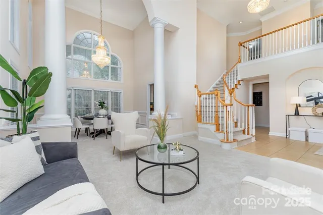 a living room with furniture a chandelier and a rug