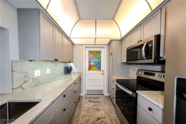 a kitchen with stainless steel appliances a stove a microwave and a sink