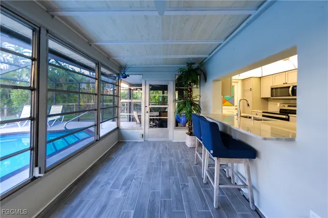 a view of a kitchen with kitchen island wooden floors and stainless steel appliances