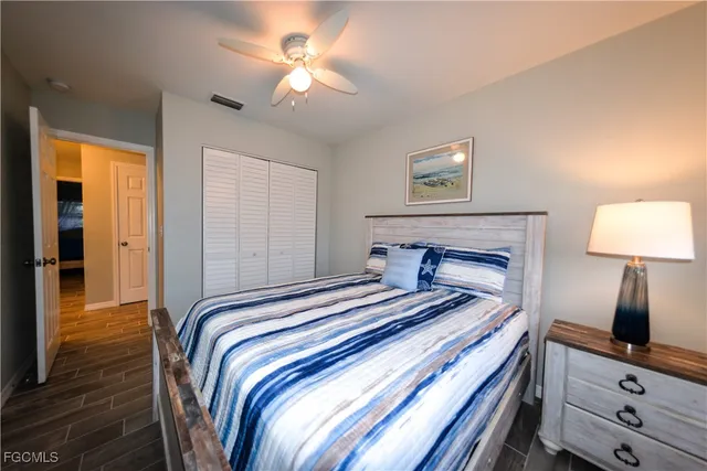 a bedroom with a bed and a lamp on a dresser