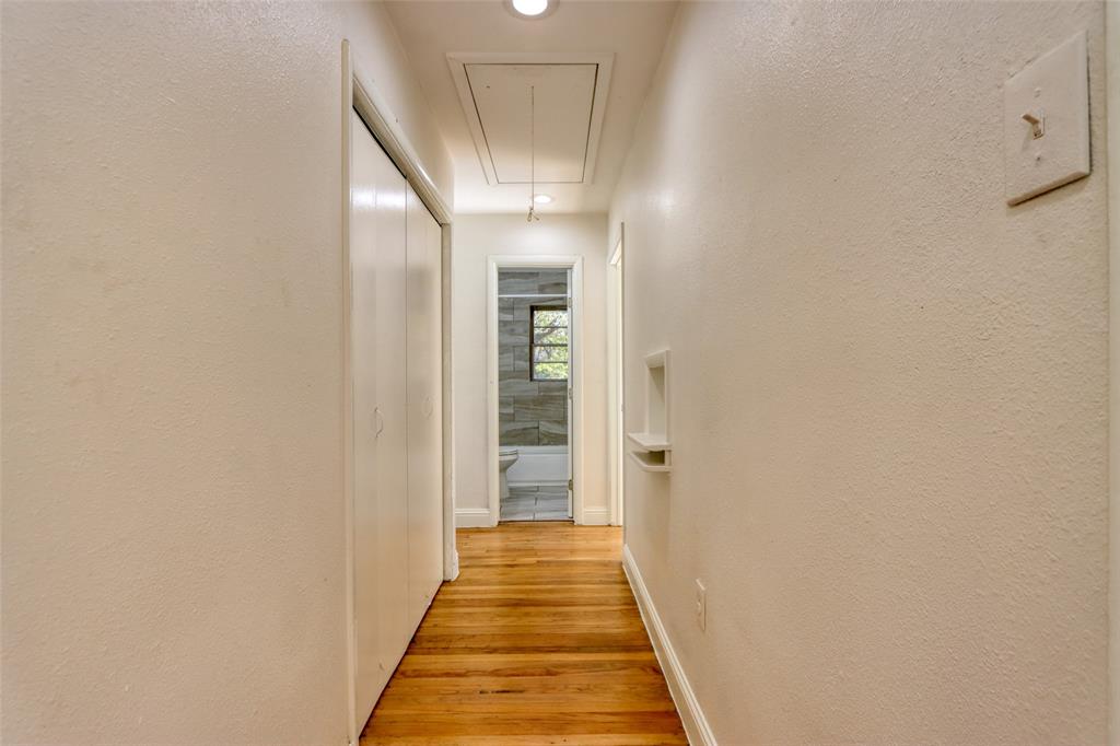 4520 Utah Avenue Dallas, TX 75216 - Photo 18 of 27 a view of a hallway with wooden floor and a bathroom