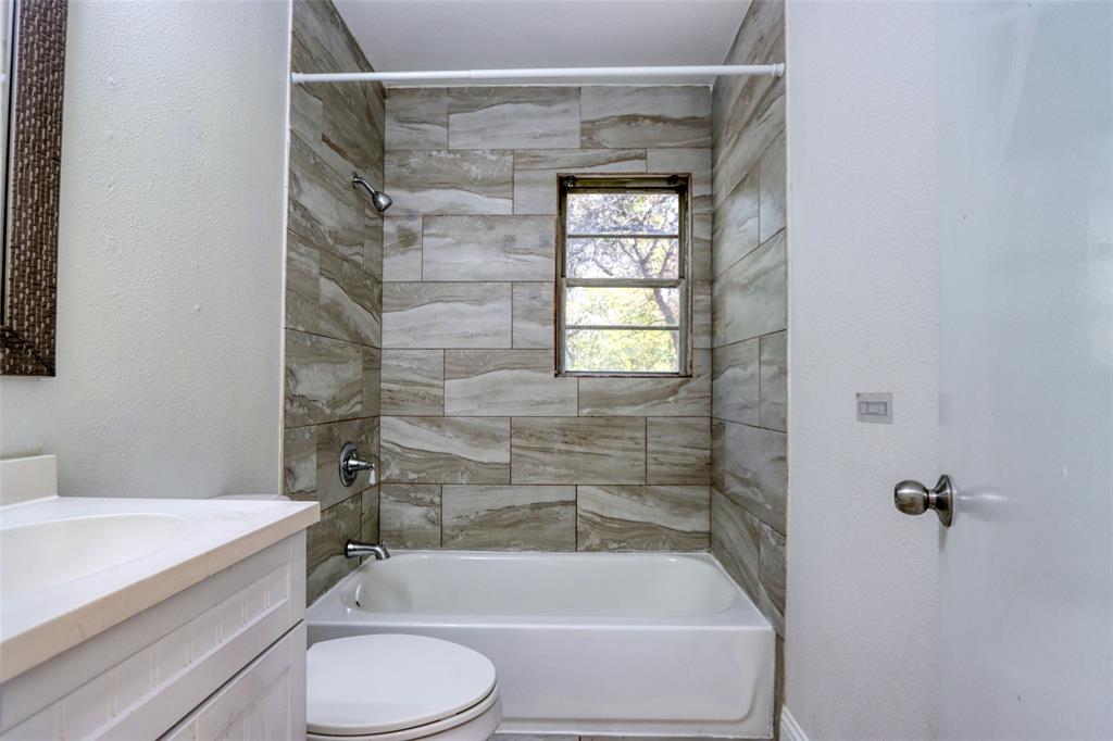4520 Utah Avenue Dallas, TX 75216 - Photo 23 of 27 a bathroom with a granite countertop bathtub toilet and sink