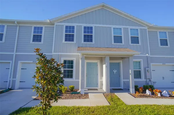 a front view of a house with a yard outdoor seating and garage