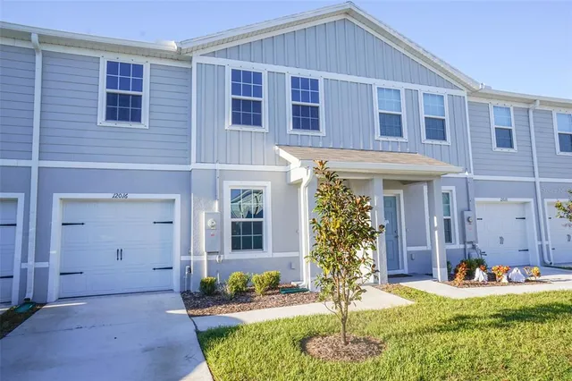 a front view of a house with a yard outdoor seating and garage