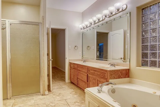 a bathroom with a tub a sink and a mirror