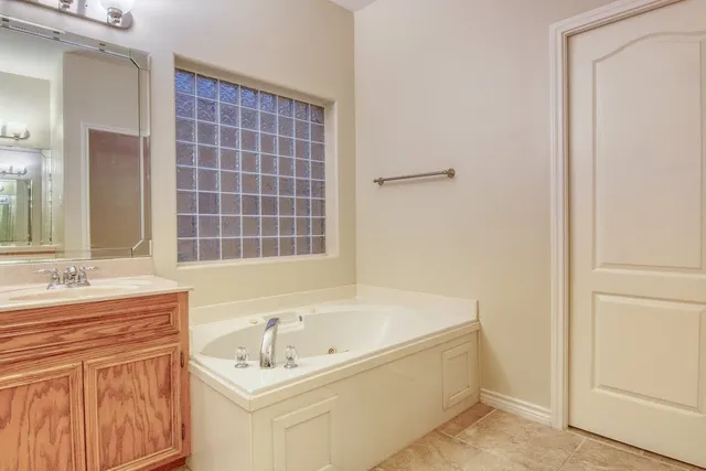a bathroom with a tub sink and mirror