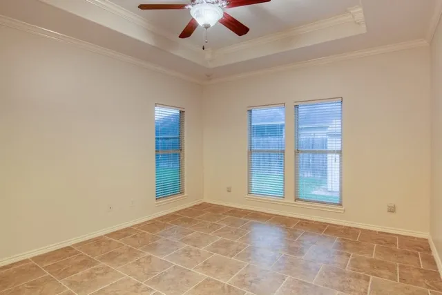 an empty room with windows and fan