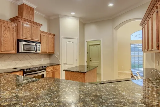 a view of kitchen with stainless steel appliances granite countertop a refrigerator a stove and a sink