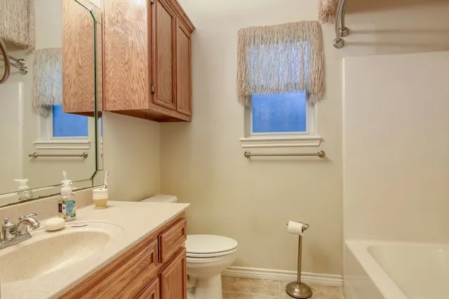 a bathroom with a sink a toilet and mirror