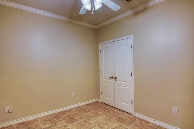 an empty room with a ceiling fan and carpet