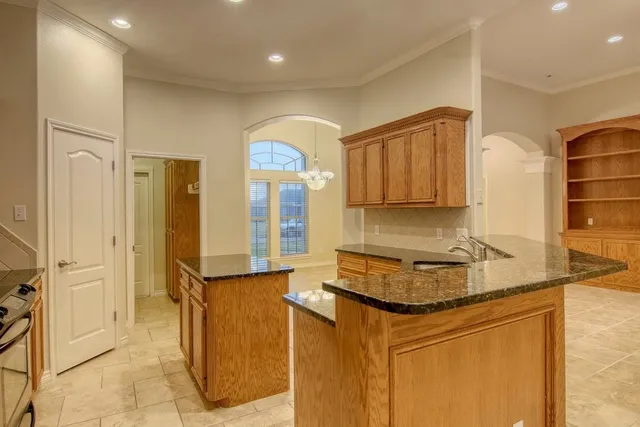 a kitchen with granite countertop a sink and a refrigerator