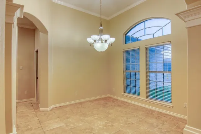 a view of a room that has a large window chandelier and a refrigerator