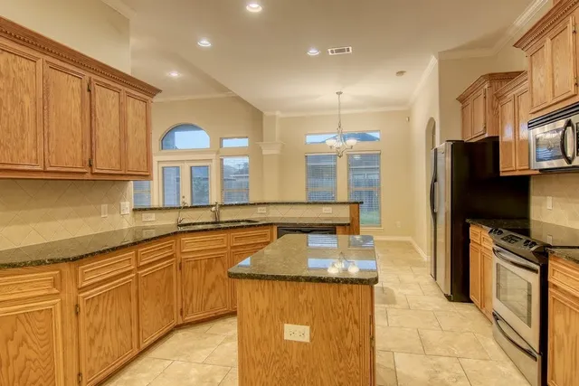 a kitchen with stainless steel appliances granite countertop a sink and a stove