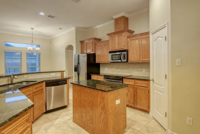 a kitchen with stainless steel appliances granite countertop a sink stove and refrigerator